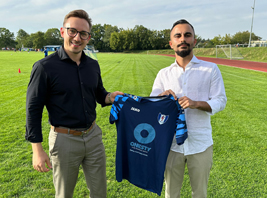 Jonas Kutzke übergibt die neuen Trikots an Miran Özkan